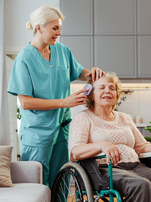 nurse-brushing-hair-of-smiling-senior-woman