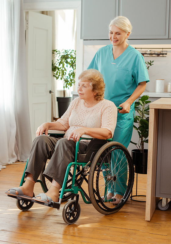 smiling-nurse-pushing-senior-woman-in-wheelchair